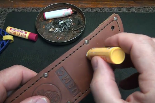 Human hands rubbing chapstick on leather