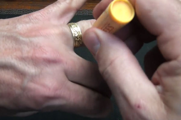 Human hands rubbing chapstick on a ring