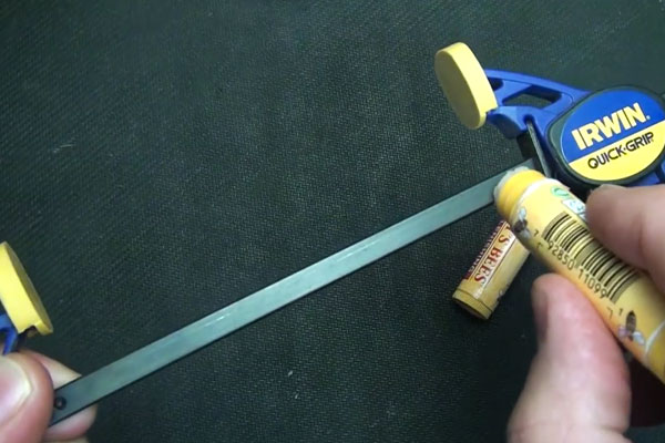 Human hands rubbing chapstick on a clamp