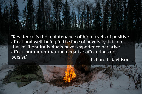 Man warming by fire in snow with mindset quote from Richard J. Davidson