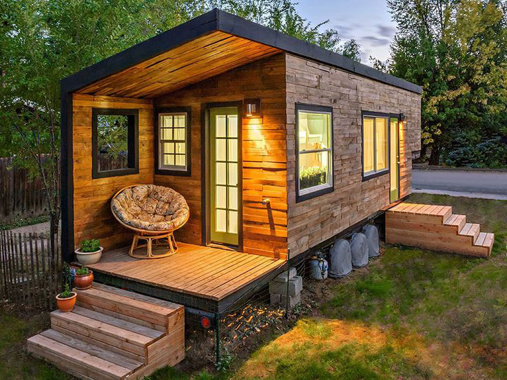 Wooden trailer home with steps and a chair
