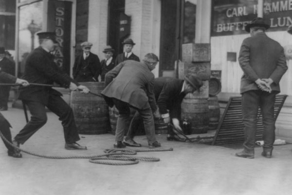 Men pulling on rope leading into underground shelter