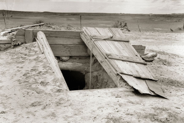 Opened wood storm shelter door built into the ground