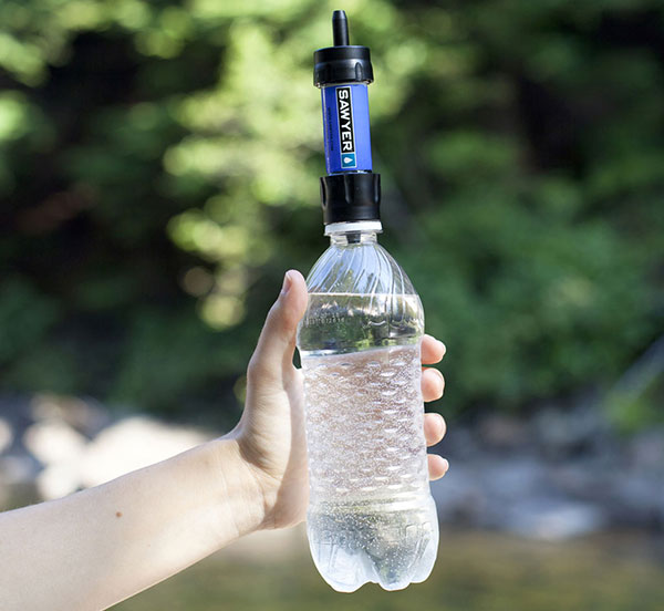 Blue sawyer filter on top of a filled water bottle