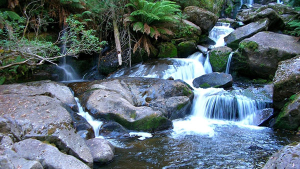 Waterfall pouring through rocks into a river