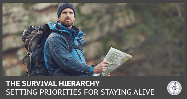 man in a jacket and beanie using a map to navigate next to a rock face