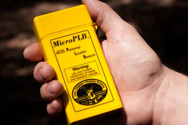 Human hand holding a MicroPLB Personal Locator Beacon