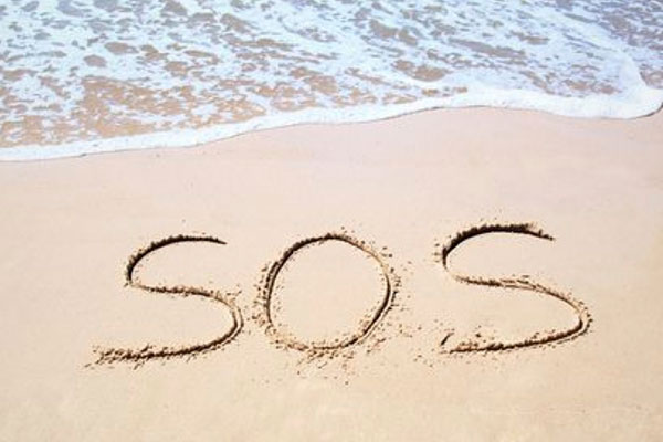 SOS signal drawn in the sand