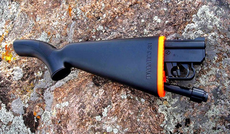 Black survival takedown rifle on a rock