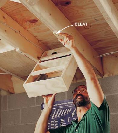 Man lowering hidden storage shelf from rafter in the ceiling