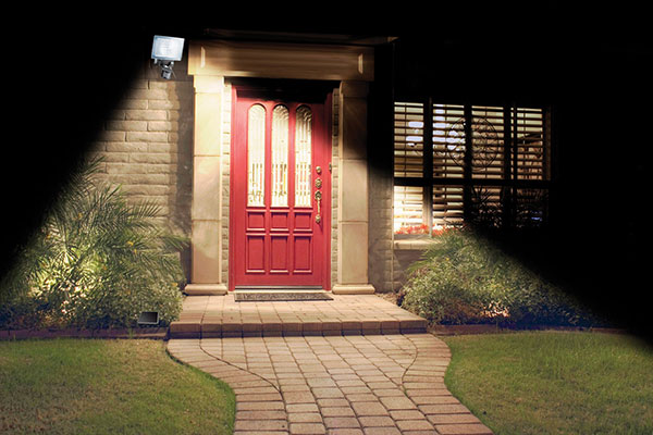 Solar motion light next to red door with window