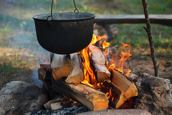 caldron hanging above a camp fire