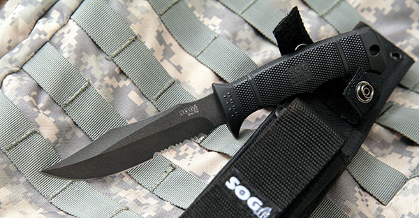 small hunting knife and sleeve on top of a camo backpack
