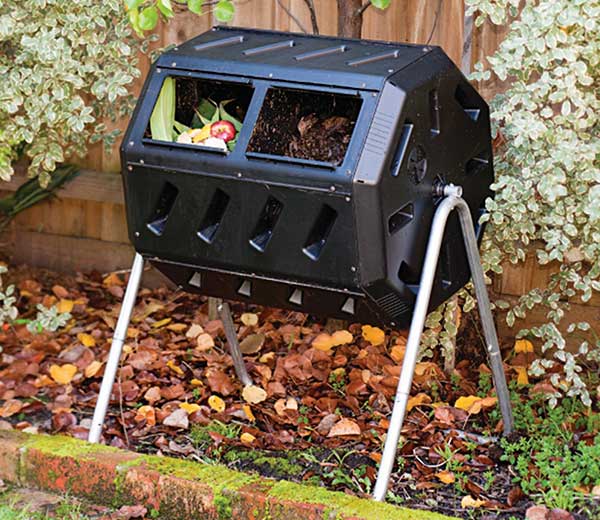 rotating composter bin on stands in a flower bed for easy composting