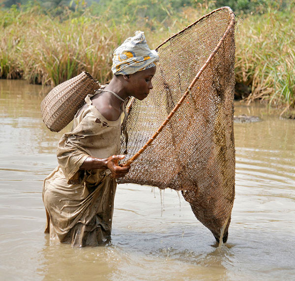 Person using a hand fishing net in a river