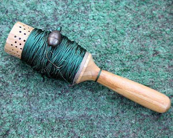 Handline for fishing with wood handle and green string