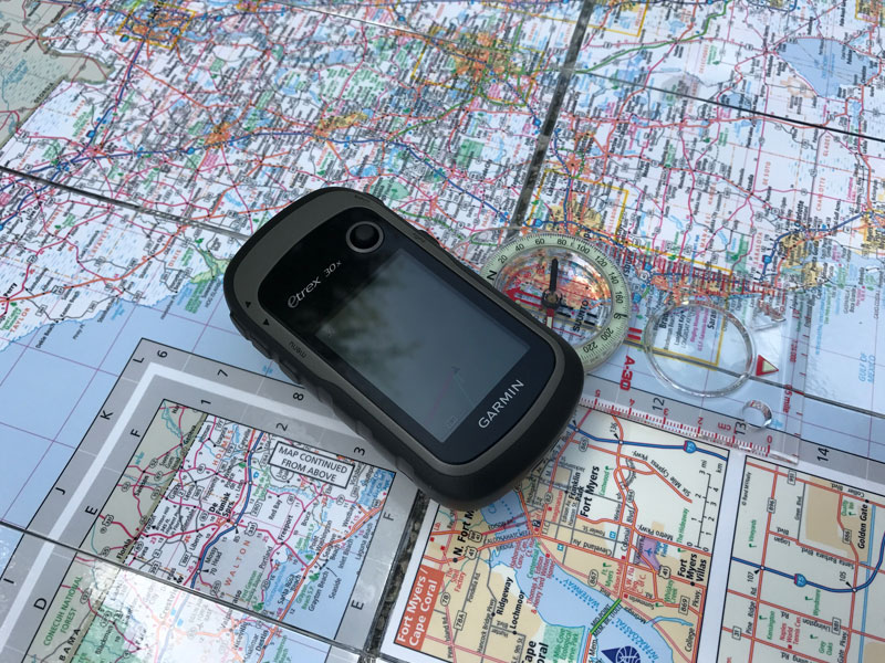 Black GPS laying on a map