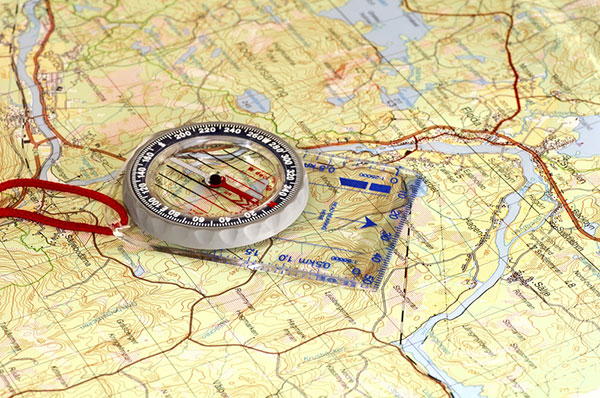 a topographical map on a table with a compass laying on top