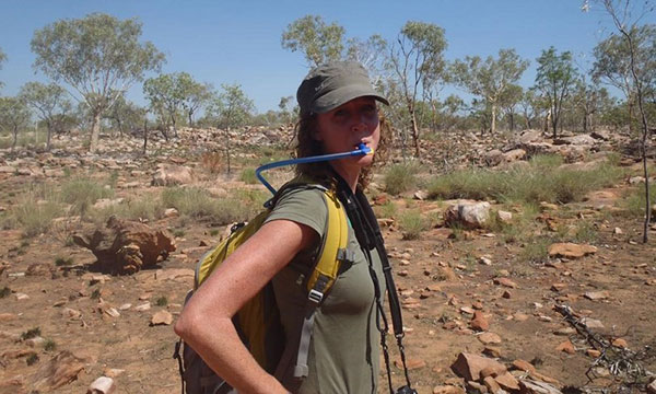 Woman drinking water from a water bladder while hiking