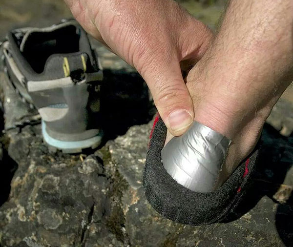 Person putting duct tape on their heel