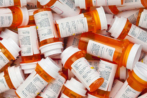 Orange bottles with white lids of prescription medications