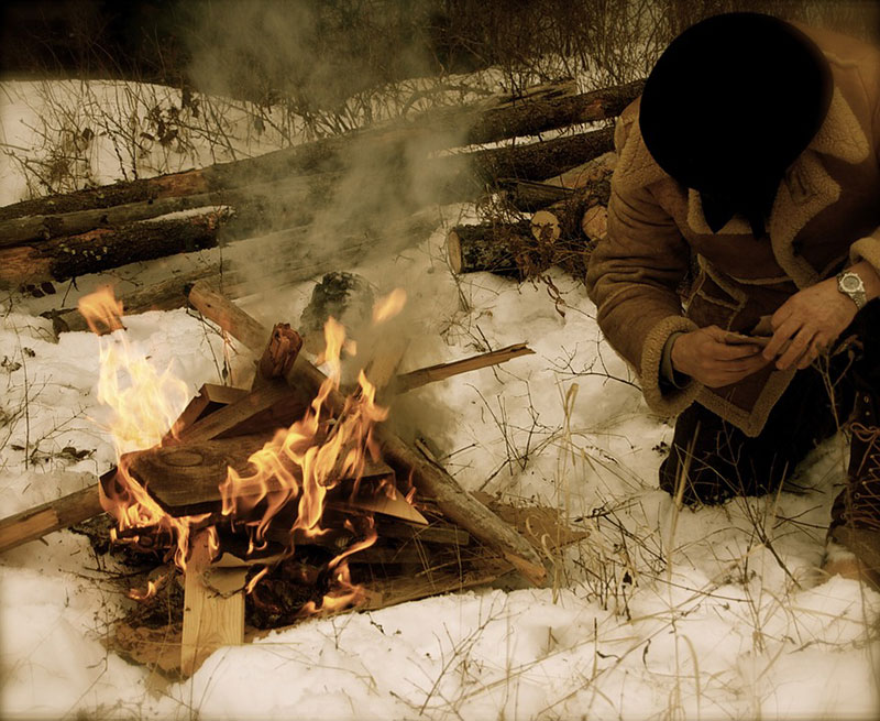 Person building a fire in the snow