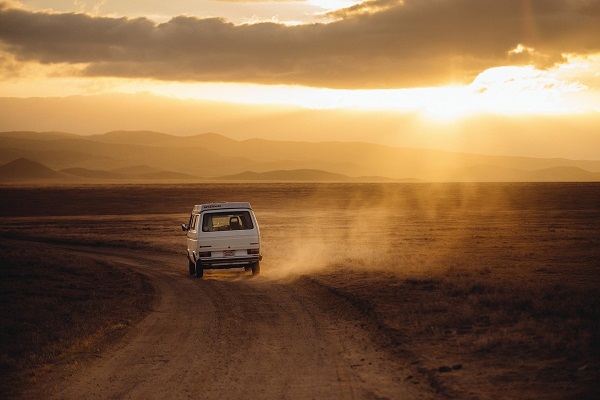 White van driving on a desert road