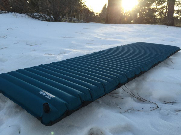 Blue sleeping mat laying on the snow