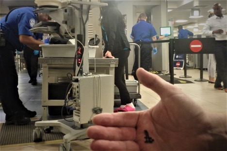 Hand holding a handcuff key in front of airport security