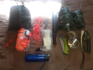 camping trip back pack contents laid out on bed