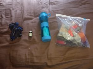 water filter iodine tabs and a second head lamp on a blanket