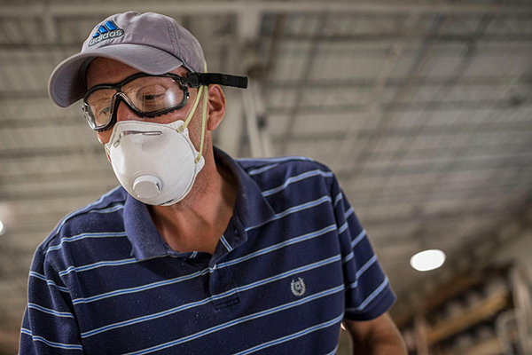 man in a factory wearing an N95 face mask