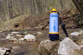 water bottle sitting on top of a rock in the middle of a stream