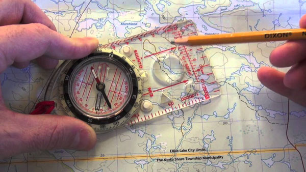 drawing a route on a map using a compass and pencil