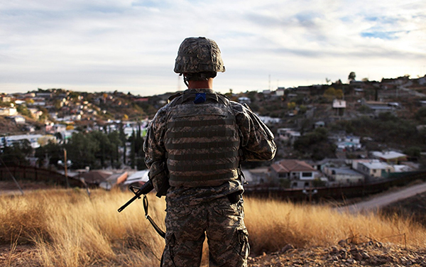 military man standing on a hill overlooking a neighborhood