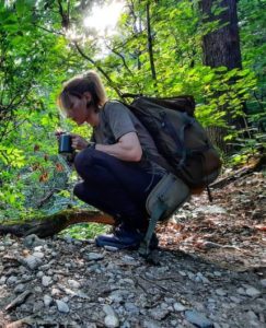 Girl drinking medicinal tea in the woods