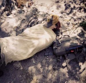 Girl in sleeping bag in the woods